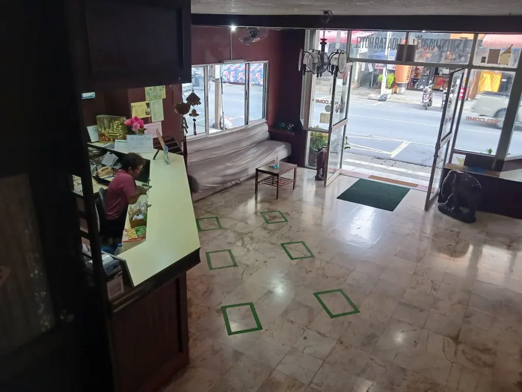 ホテルのフロント。入り口の扉は開いており、カウンターにスタッフ１人がいる