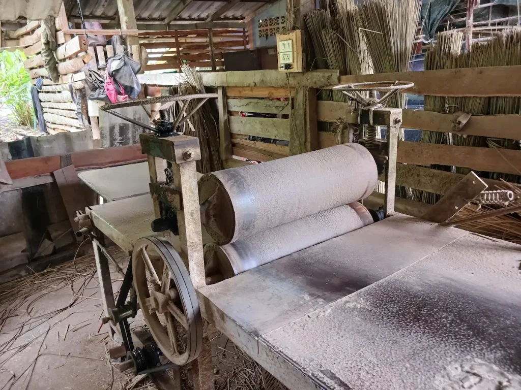 建物の中に置かれた、水草を平らにする手動の機械。古びた金属の機械