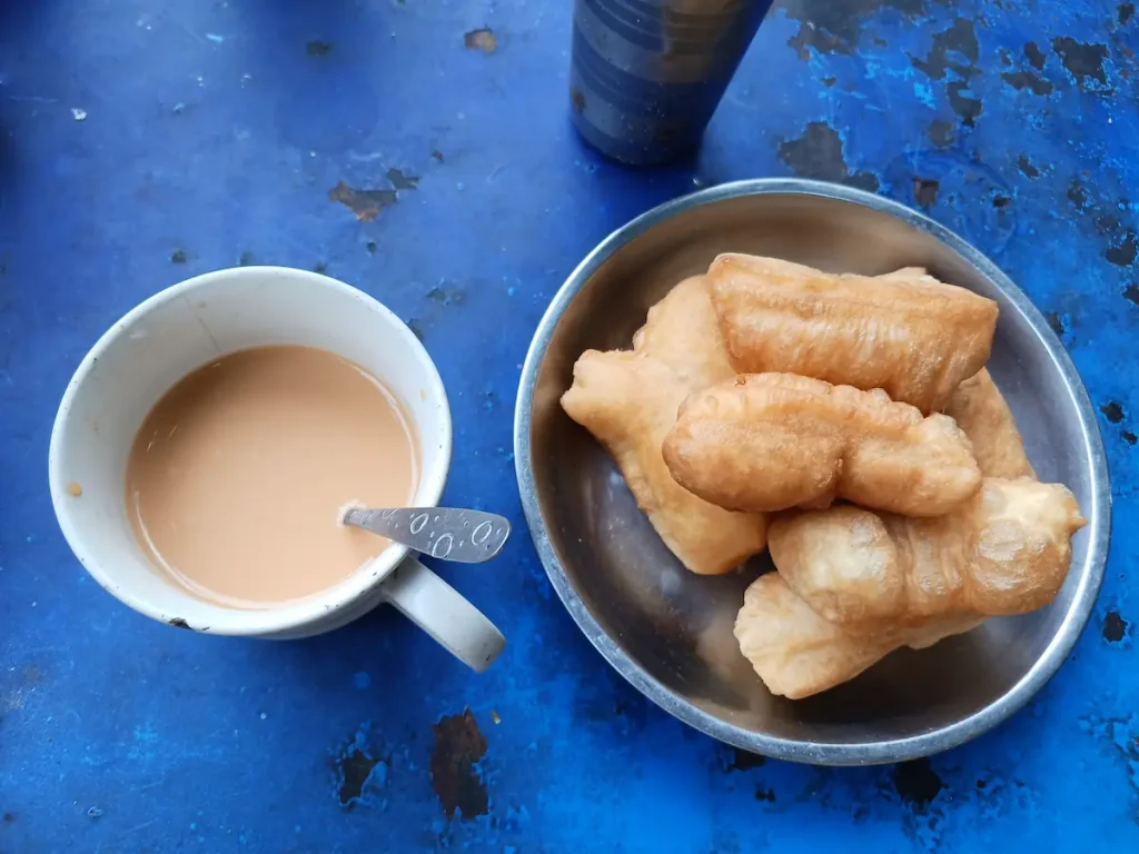 机の上に置かれたタイのパトンコー（Pa Tong Go）と呼ばれる揚げパンとチャイ