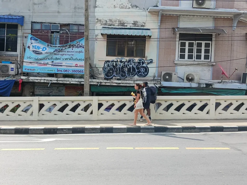 半袖短パン姿の男女が大きなリュックを背負ってSamSenロードを北に向かって歩いている