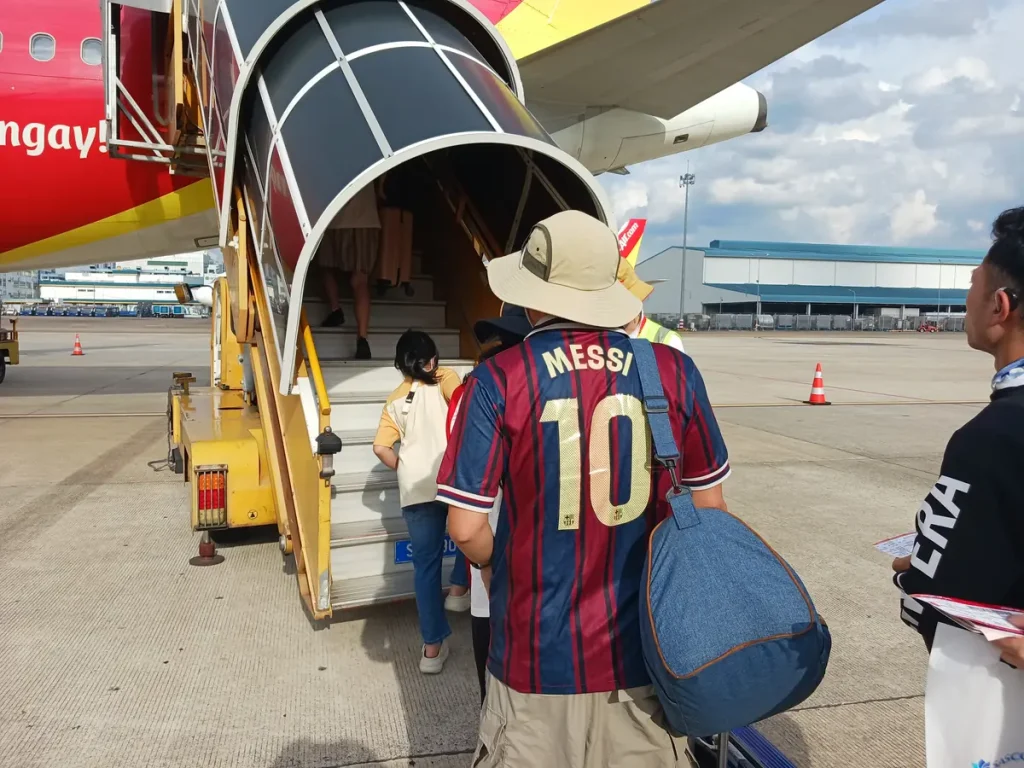 ベトナムのタンソンニャット国際空港にて飛行機に搭乗する人々