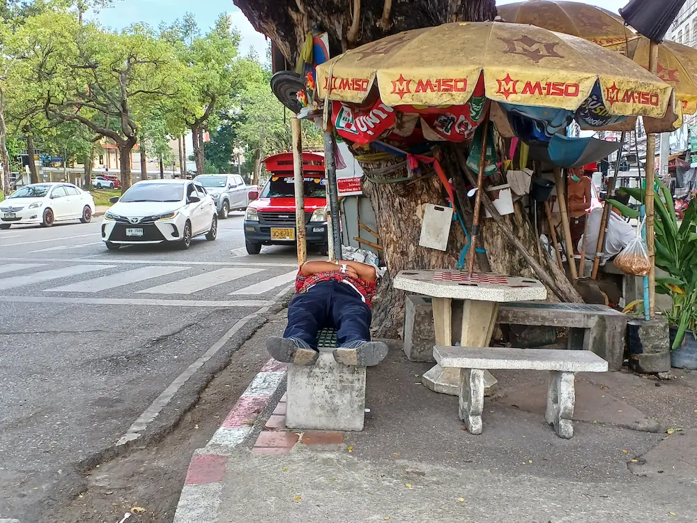 チェンマイの街中のベンチで眠る男性